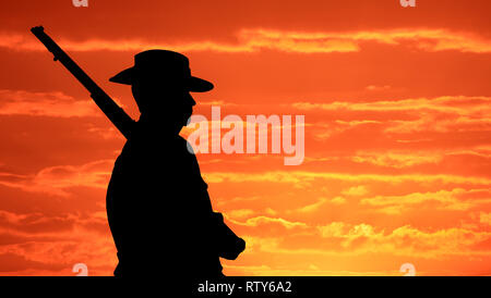 Silhouette of an Australian Soldier in AIF First World War dress with slouch hat and 303 Rifle at sunrise ANZAC tribute. Stock Photo