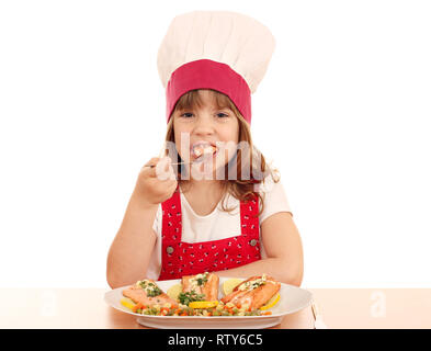 hungry little girl cook eats salmon seafood Stock Photo