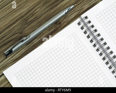 close up of blank notebook and a pen on wooden office desk with copy space Stock Photo