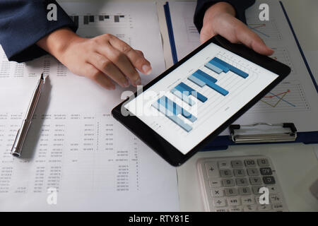 Women working in office. financial analysis with charts on pad for business, accounting, insurance or finance concept Stock Photo