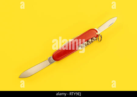 Tabletop view, red pocket knife, with both blades opened, laying on yellow board. Stock Photo