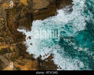 Aerial view of sea waves crash on the shoreline