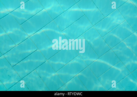 Underwater photo - old swimming pool bottom. Blue tiles pattern visible on floor. Abstract water background. Stock Photo