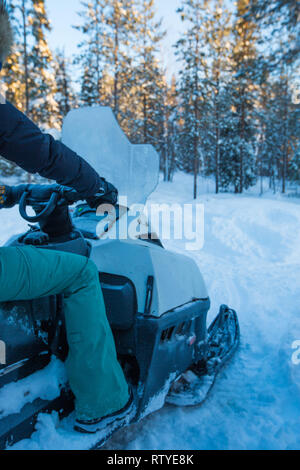 Rider on the snowmobile in winter snow in the morning side view unrecognizible person Stock Photo