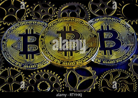 Digital illustration of three bitcoins among cog wheels. Cryptocurrency conceptual artwork. Stock Photo