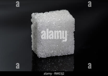 one single piece cube sugar on black background - detailed macro image, photographed in studio with atrificial light Stock Photo