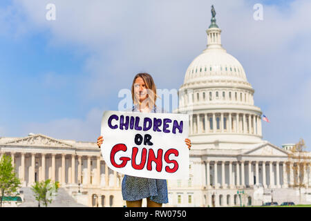 Woman protest in front of the USA capitol in Washington holding sign saying children or guns Stock Photo