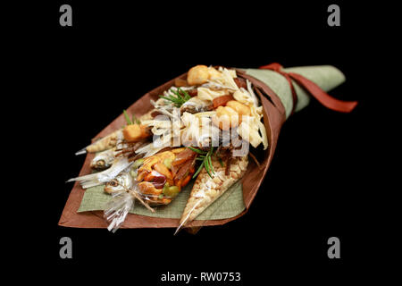 Original bouquet consisting of dried salted fish, salted peanuts, crackers, dried bread and other beer snacks isolated on black background as male gif Stock Photo