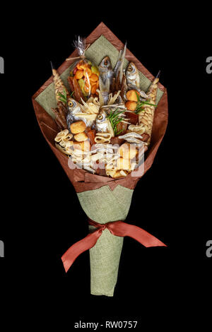 Original bouquet consisting of dried salted fish, salted peanuts, crackers, dried bread and other beer snacks isolated on black background. Top view Stock Photo