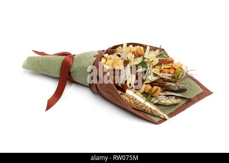 Original bouquet consisting of dried salted fish, salted peanuts, crackers, dried bread and other beer snacks isolated on white background. Side view Stock Photo