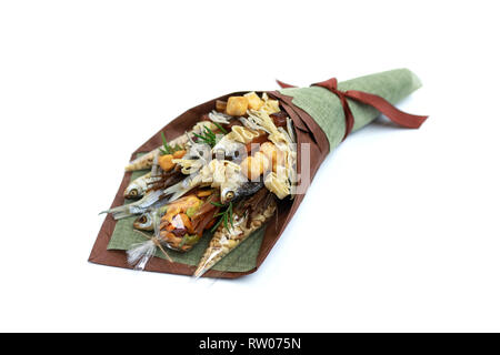 Unique bouquet consisting of dried salted fish, salted peanuts, crackers, dried bread and other beer snacks isolated on white background. Top view Stock Photo