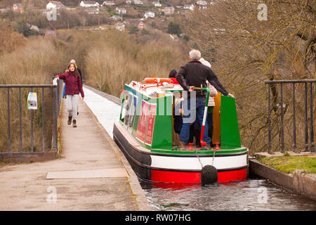 Man steering a narrow boat over the Pontcysyllte aqueduct on the Llangollen canal  in North Wales above the river Dee built by Thomas Telford 1805 Stock Photo