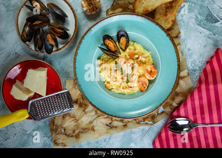 photo of delicious risotto with saffron and seafood on table. Stock Photo