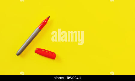 Top view on red marker, cap opened, on yellow board, copyspace for your text on right side. Stock Photo