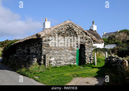 A restored thatched roof Manx cottage at the National Folk Museum in a small hamlet of Cregneash on the southwest coast of the Isle of Man, Britain.   Stock Photo