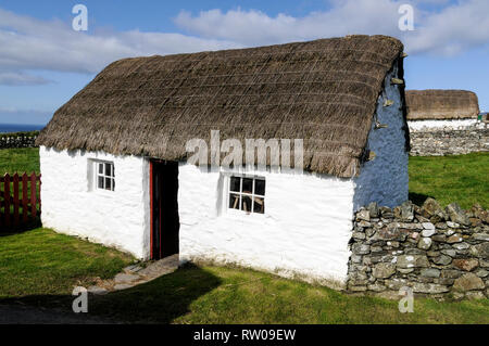 A restored thatched roof Manx cottage at the National Folk Museum in a small hamlet of Cregneash on the southwest coast of the Isle of Man, Britain.   Stock Photo