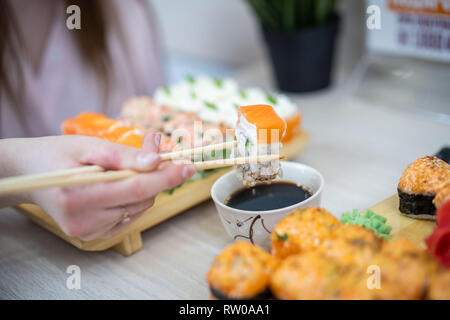 girl eating sushi set with chopsticks on restaurant . close up Stock Photo