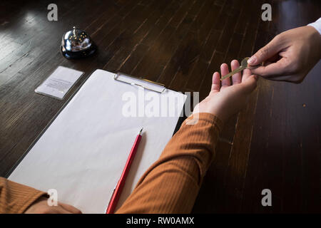 Close up of hand guest takes room key at check-in desk of the hotel.Hotel concept. Stock Photo