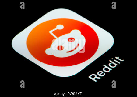 A close-up shot of the Reddit app icon, as seen on the screen of a smart phone (Editorial use only) Stock Photo