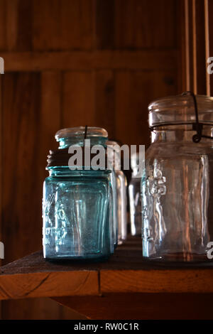 Vintage lidded glass jars on a wooden shelf with wooden slat background. Shingle Creek Pioneer Village, Kissimmee, Florida, USA Stock Photo