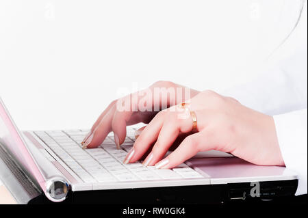 Woman hands typing on laptop keyboard over white background Stock Photo