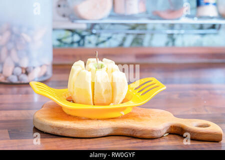 Cutting the apple into slices with a special device. Stock Photo
