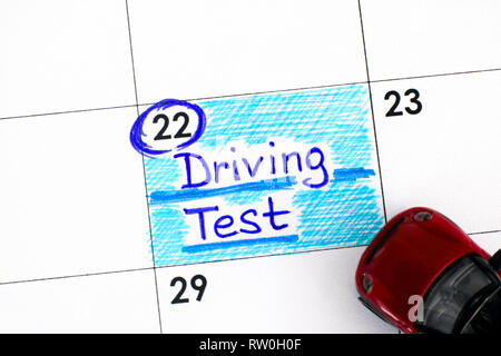 Reminder Driving Test in calendar with red toy car. Close-up. Stock Photo