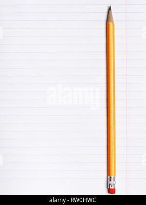 Orange pencil lies on a sheet of paper notebook with lines of inclination. The concept of education. Stock Photo