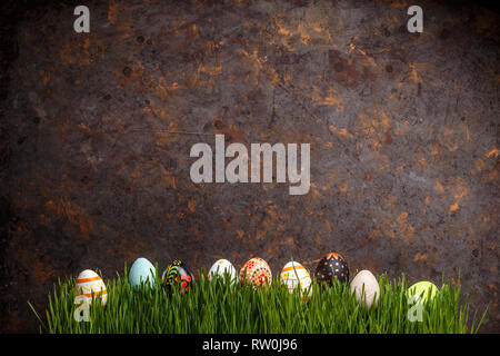 Easter eggs lined up in a row on grungy dark background, copy space Stock Photo