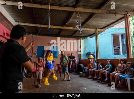 Latin bambini alla festa di compleanno in esecuzione dopo la caramella al  di fuori di un'pinata in Guatemala Foto stock - Alamy