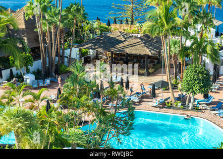 Tenerife Costa Adeje luxury hotel.  Right by the sea the hotel pool is surrounded by palm trees. Stock Photo