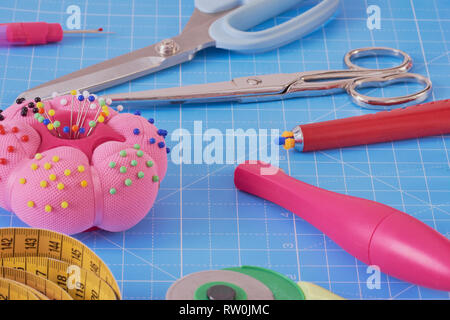 essential sewing equipment on a blue cutting mat Stock Photo