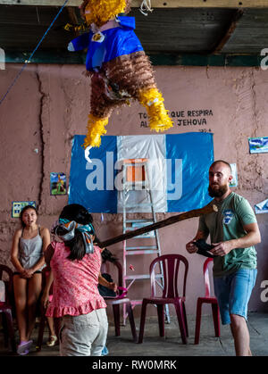 latin children at birthday party running after candy out of a pinata in Guatemala Stock Photo