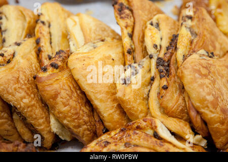 Delicious fresh pastry croissants with tiny chocolate chips at a market Stock Photo