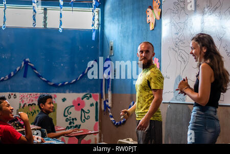 man and woman teaching latin children in Guatemalan classroom Stock Photo