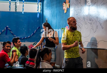 man and woman teaching latin children in Guatemalan classroom Stock Photo