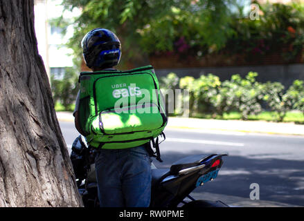 Lima, Peru - March 3 2019: Uber eats driver working at food delivery service. Sharing collaborative economy concept in South America. Stock Photo