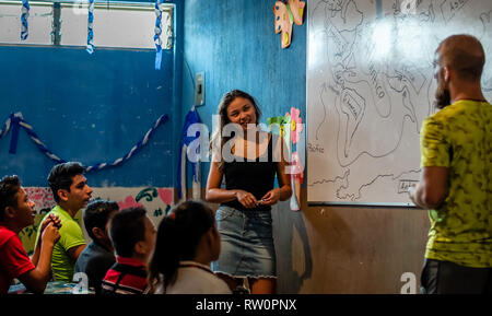 man and woman teaching latin children in Guatemalan classroom Stock Photo