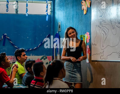 man and woman teaching latin children in Guatemalan classroom Stock Photo