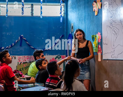 man and woman teaching latin children in Guatemalan classroom Stock Photo