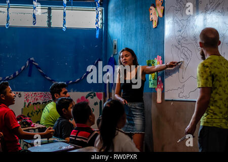 man and woman teaching latin children in Guatemalan classroom Stock Photo