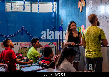 man and woman teaching latin children in Guatemalan classroom Stock Photo