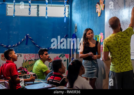 man and woman teaching latin children in Guatemalan classroom Stock Photo