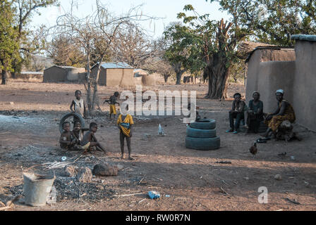 A photo of Ghanaian children posing for the camera as they are playing with old car tyres in the yard. Taken in a savanna of Ghana. Stock Photo