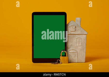 tablet screen lock with green screen on yellow background Stock Photo