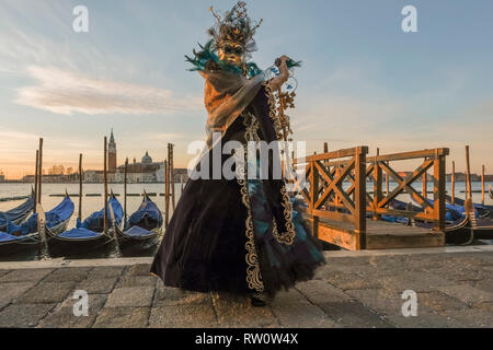 VENICE, ITALY - FEBRUARY 24: People wearing carnival costumes pose at sunrise in St. Mark square. The theme for the 2019 edition of Venice Carnival is Stock Photo