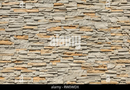 Tiled stone wall made of rectangular blocks, sun shining from top. Stock Photo