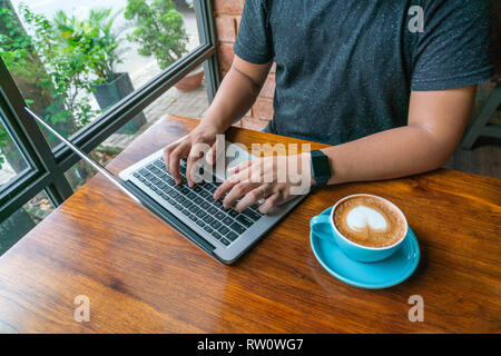 Young man in casual clothes using laptop Stock Photo