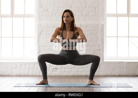 Woman practicing yoga, standing in Goddess pose, Sumo Squat exercise Stock  Photo | Adobe Stock