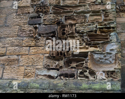 Weathered sandstone on an ancient building showing how weather and climate can wear away stone over time Stock Photo